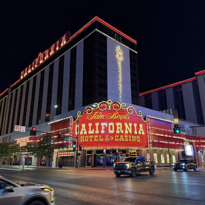 Exterior of The CAl at night, with it's signature red neon sign in focus.