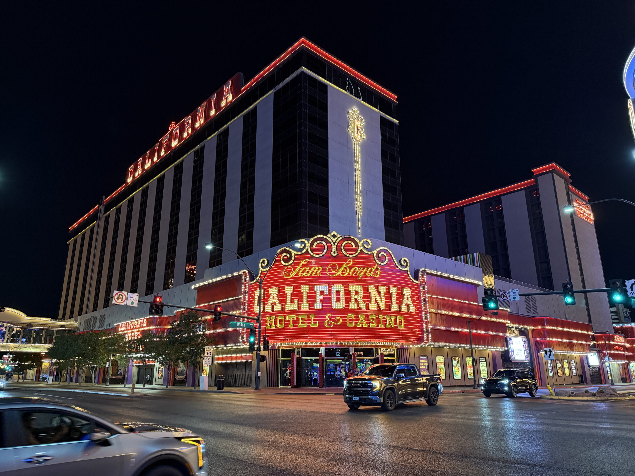 Exterior of The CAl at night, with it's signature red neon sign in focus.