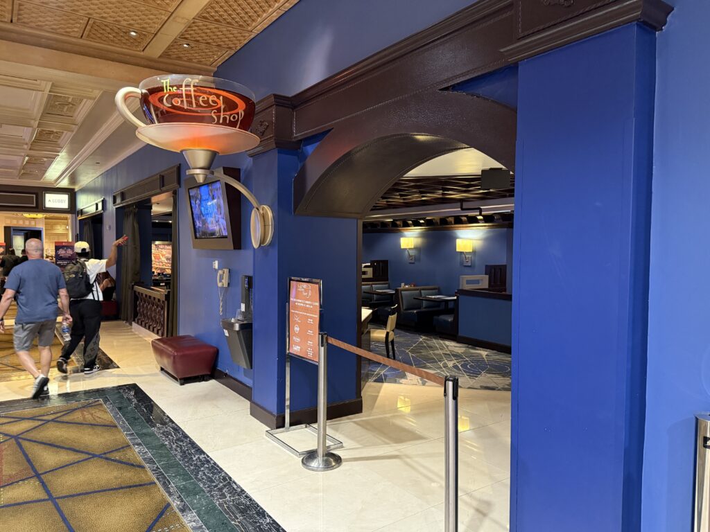 Exterior of The Coffee Shop, which has a sign shaped as a 3D cup of coffee.