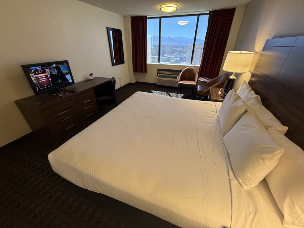 A wide angle shot that shows the king bed pointed at a tiny TV.
