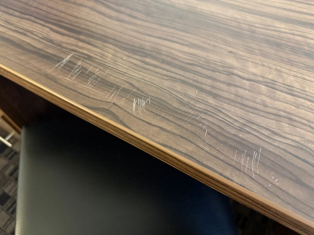 Scrated atop a faux wood desk.