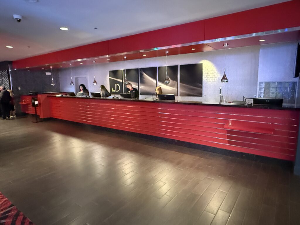 A bright red hotel front desk in the main lobby.