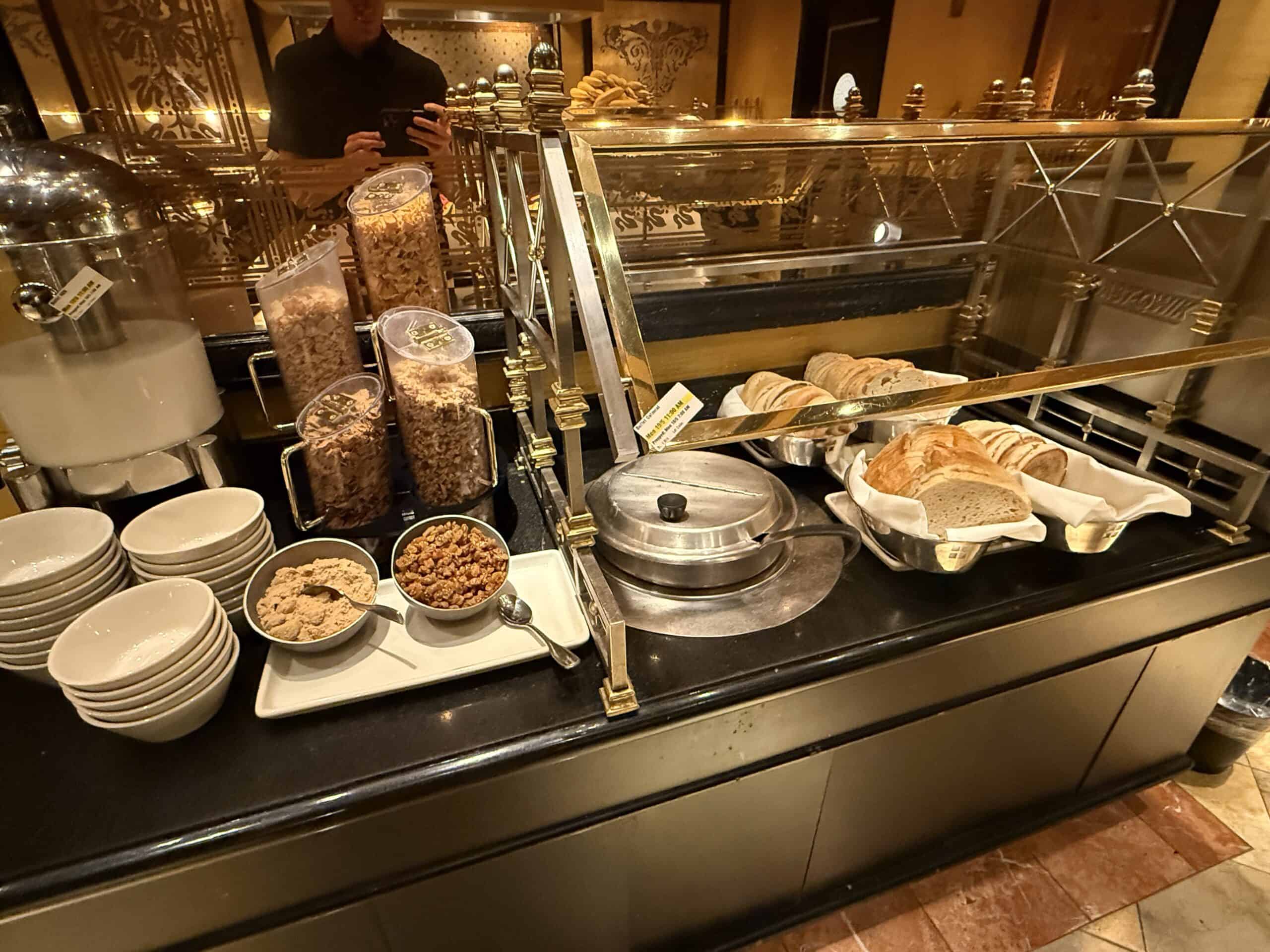 A cereal station stocked with several options, bread, a toaster, and oatmeal.