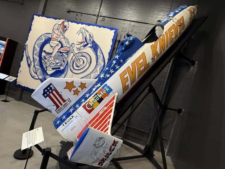 Evel Knievel's Skycycle on a ramp in front of a promotional poster for the Snake River Jump.