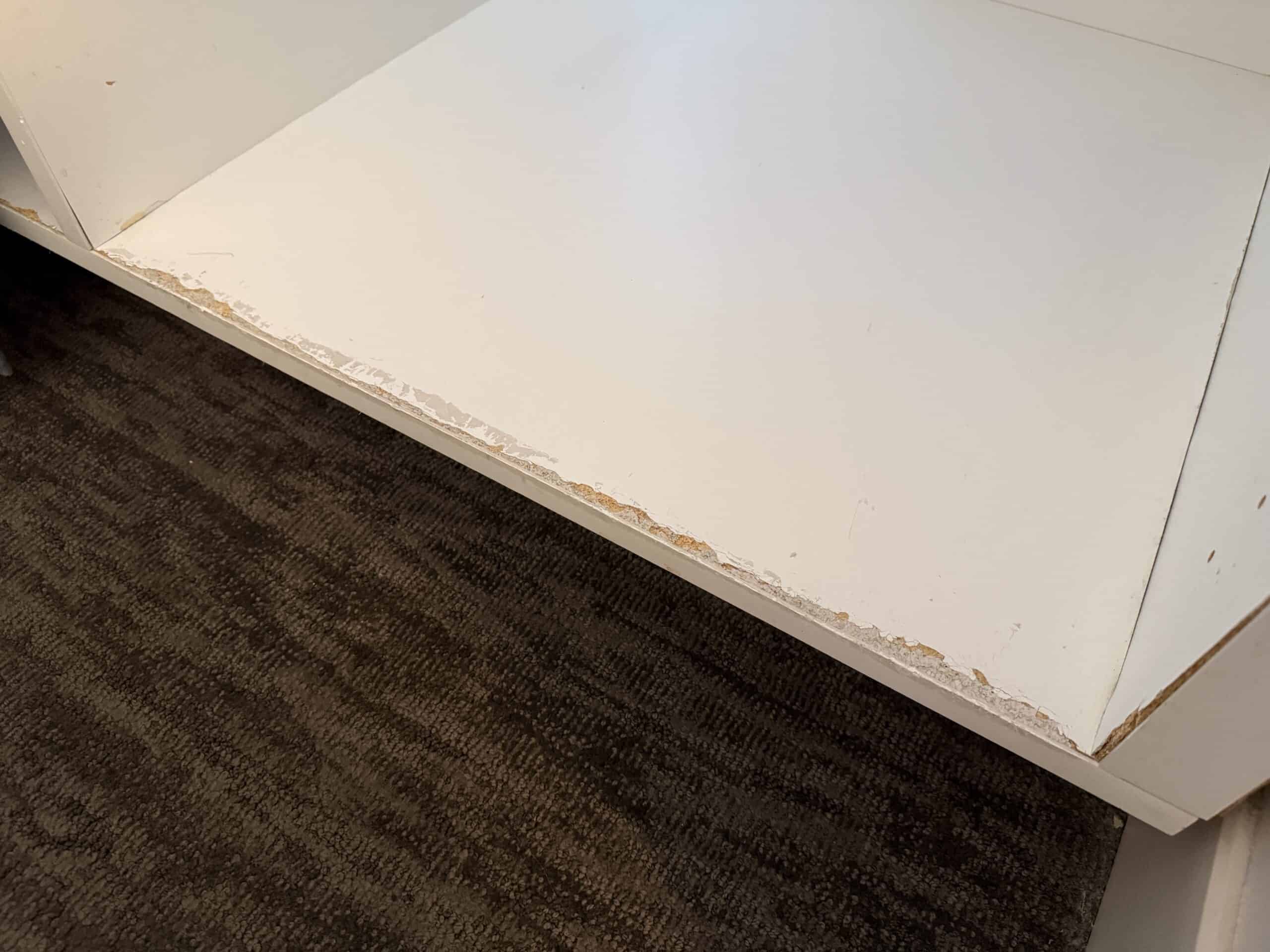 A shelf in the closet with a chipped suface.
