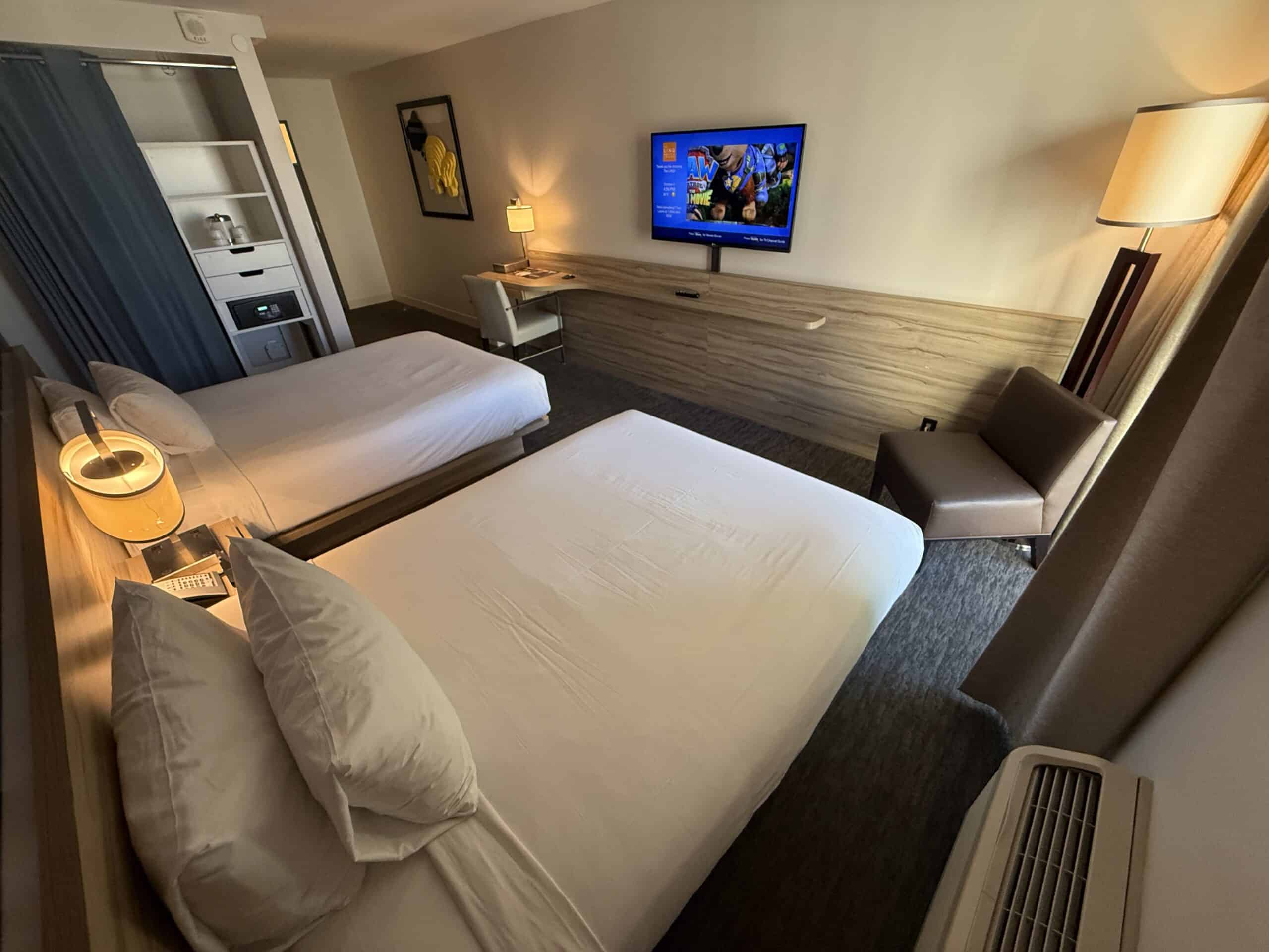A wide angle shot of the room that shows the beds pointed at a small, wall-mounted TV.