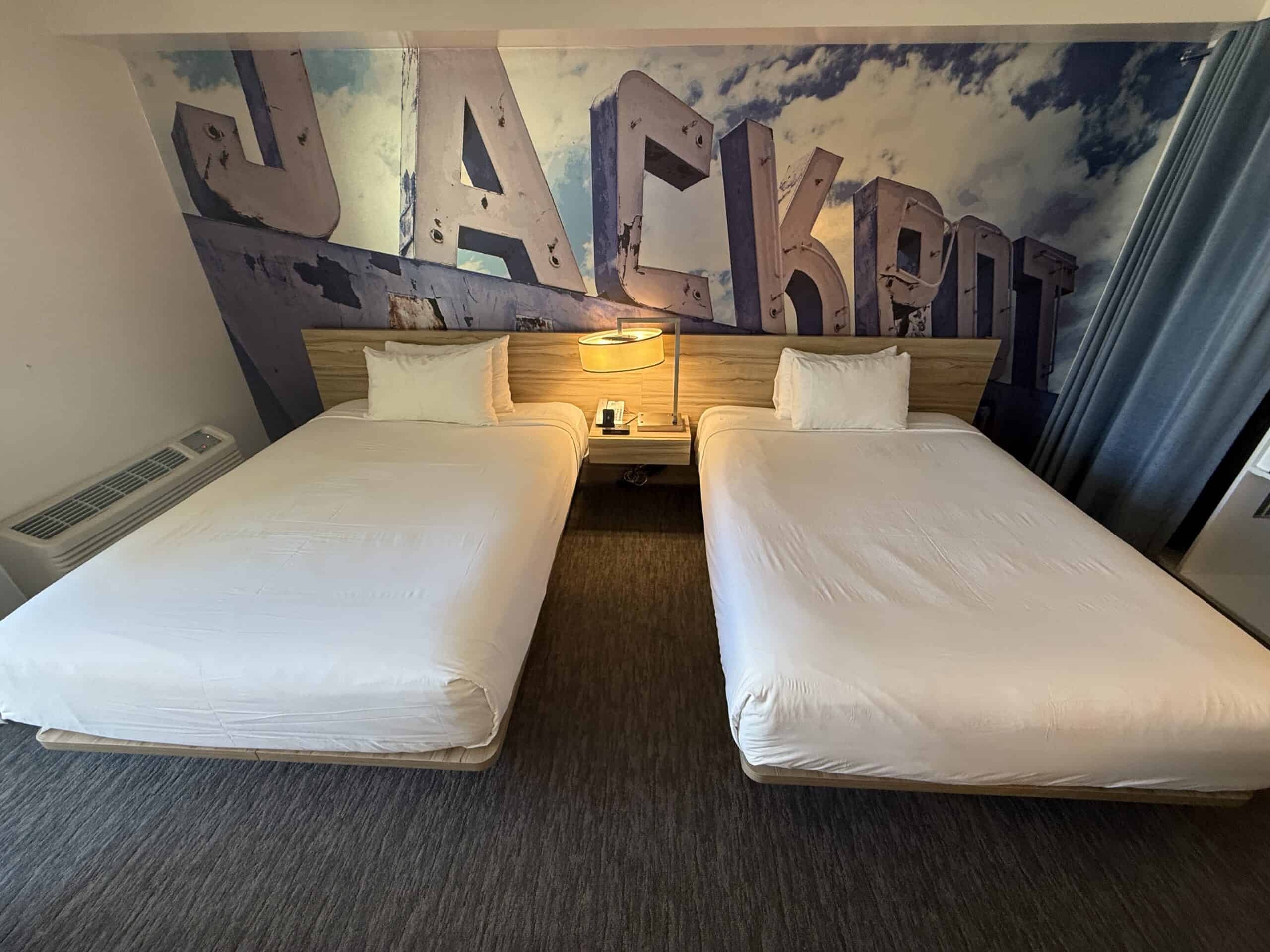 The two full beds, with a lamp between against the "Jackpot" accent wall.