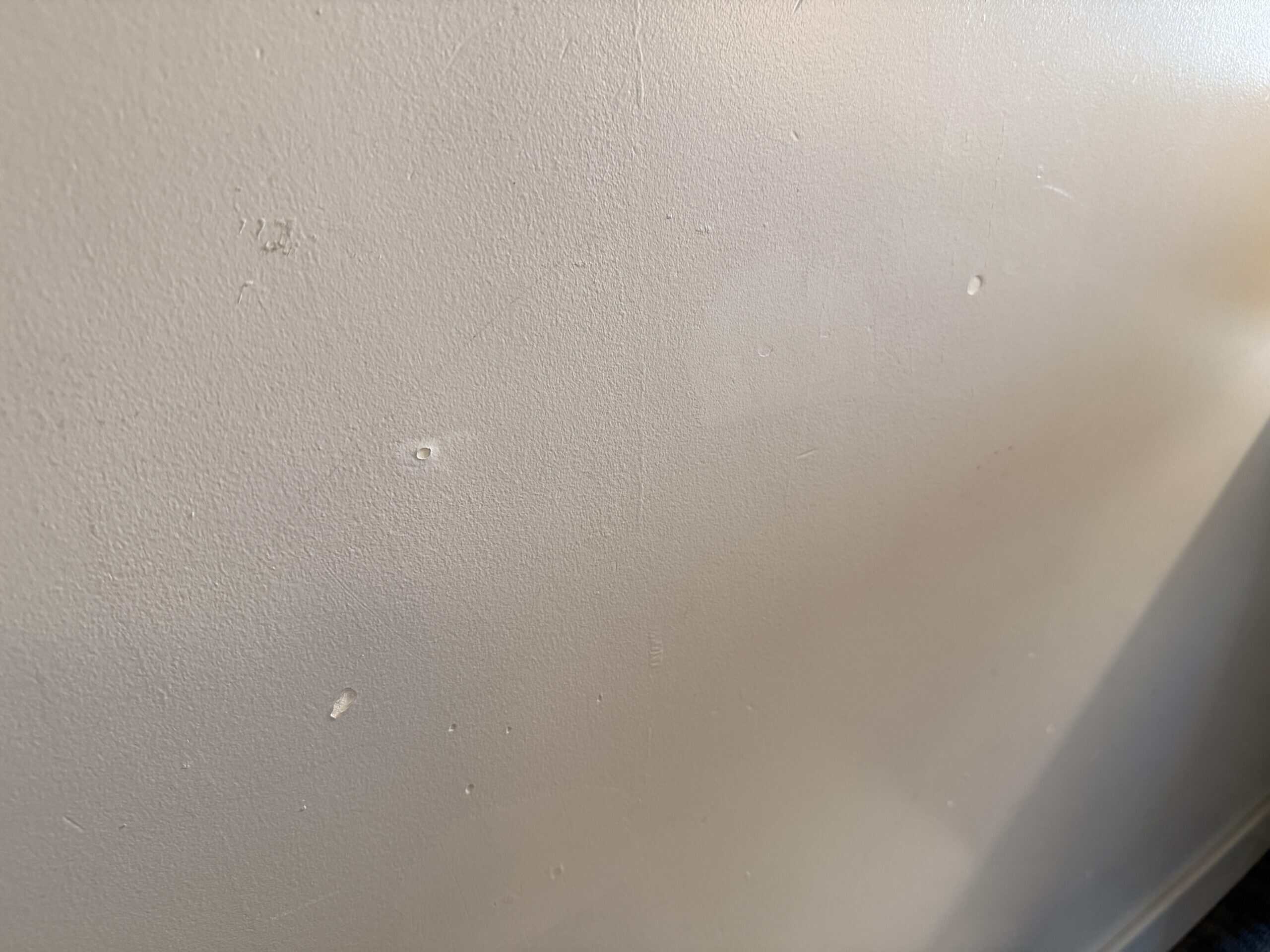 Scuffs and gouges in the wall.