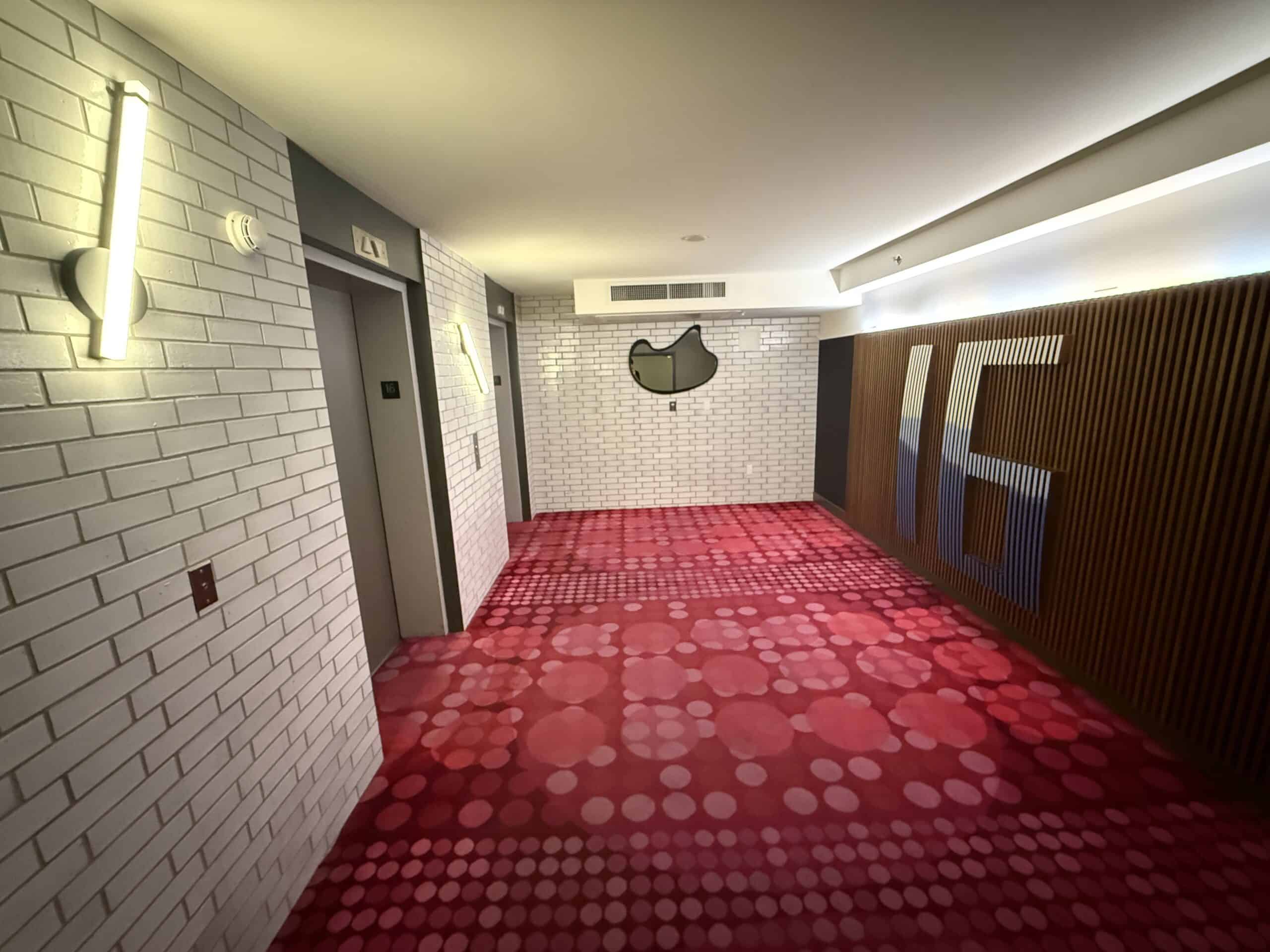 A small elevator lobby, with a 16 decoratively prodtruding from the wall to signify this is the 16th floor.