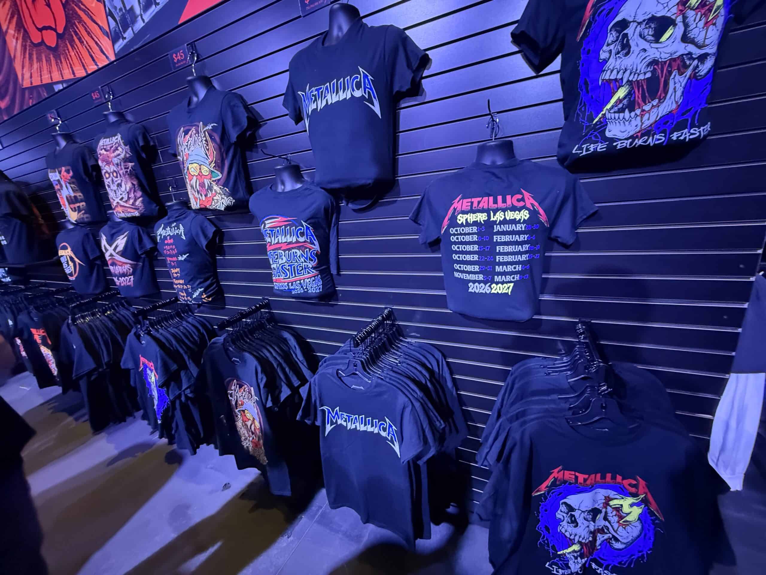 Metallica shirts, displayed hanging from a wall.