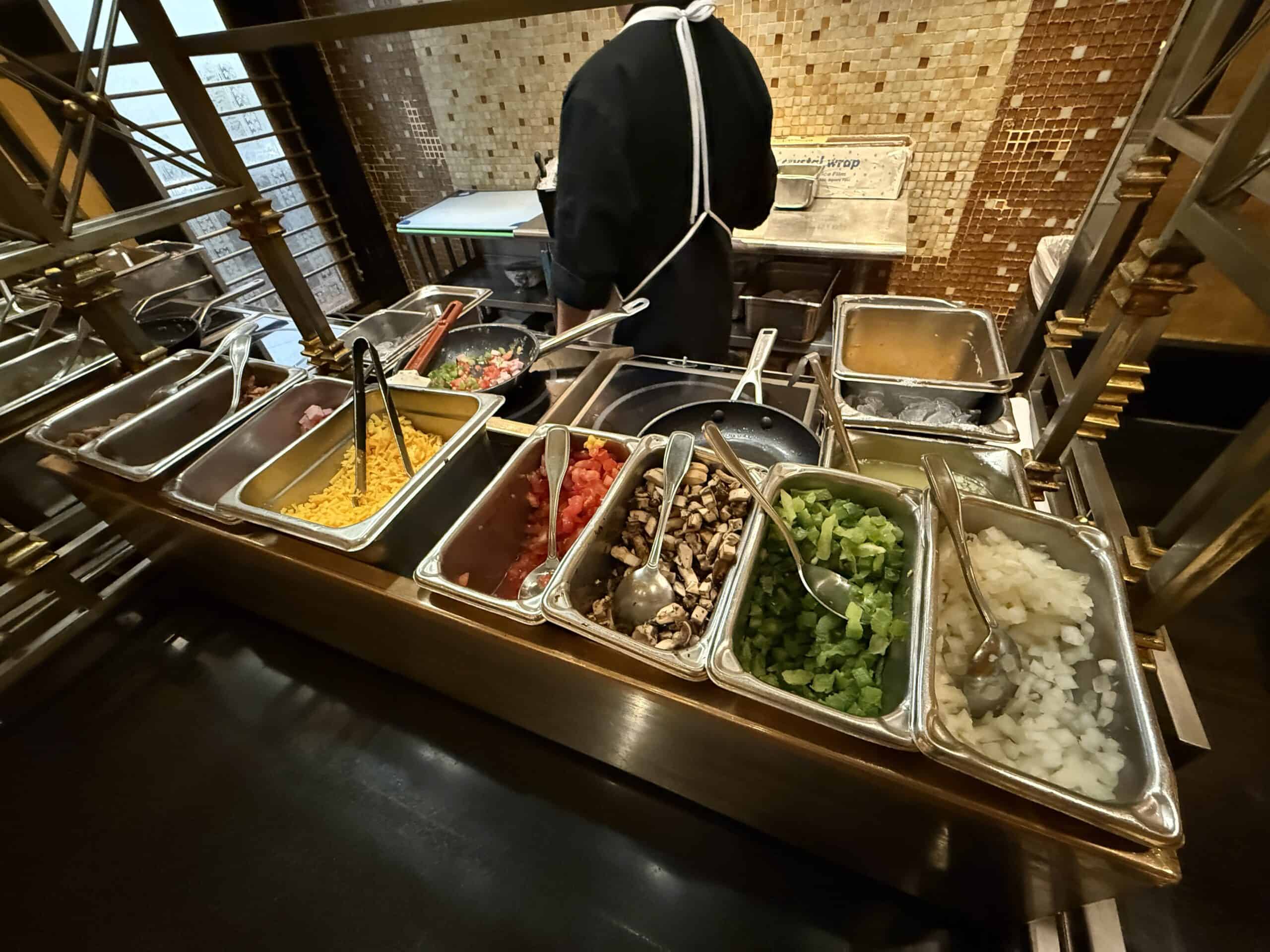 The omelette station, with all of your topping options that include onions, green peppers, tomato, mushrooms, cheese, and more.