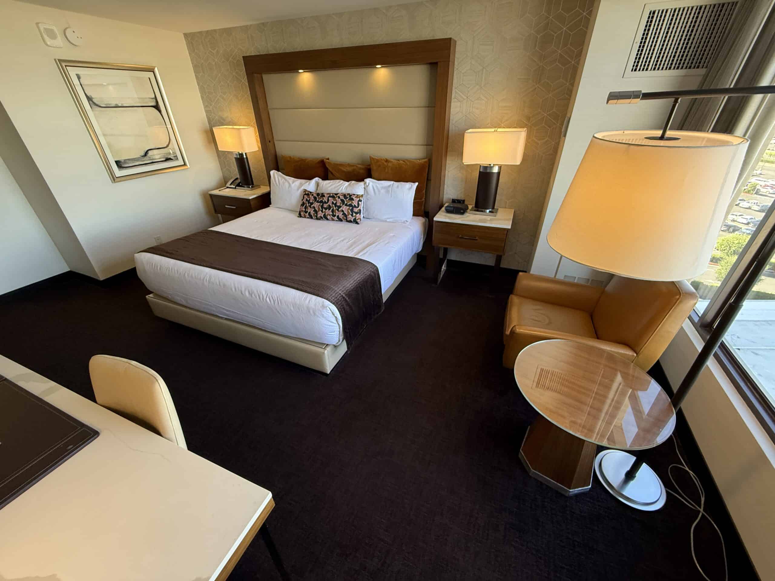 Another wide angle view of the room that shows the window to the right and bed in the back left.