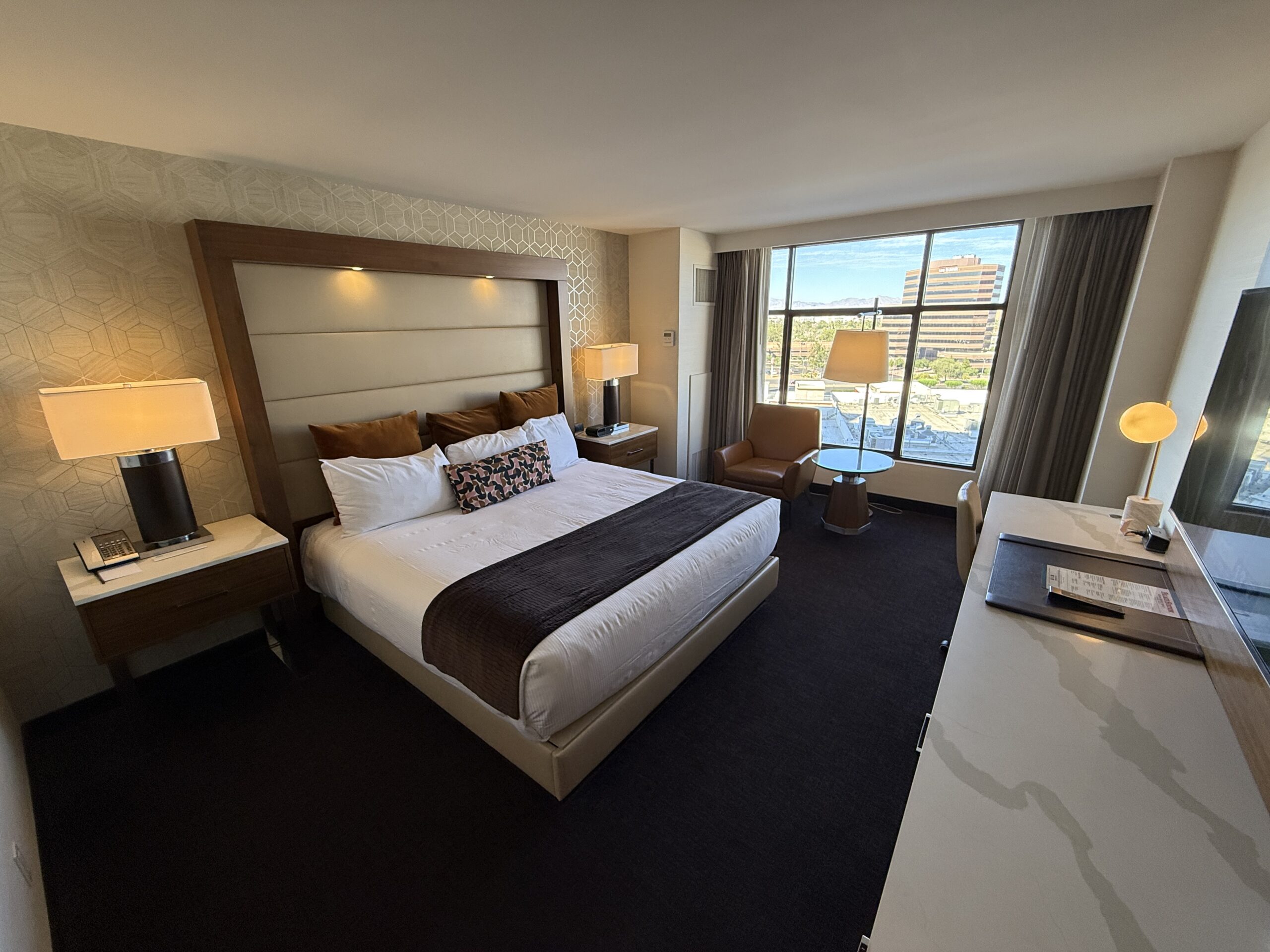 A wide angle view of the Premier King room with the bed to the left and window in the back ground.