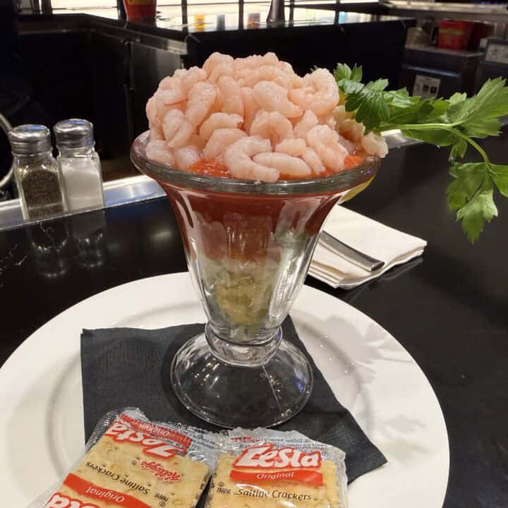 $2.99 Shrimp Cocktail side profile with a pile of shrimp on top, on a bed of cocktail sauce and lettuce.