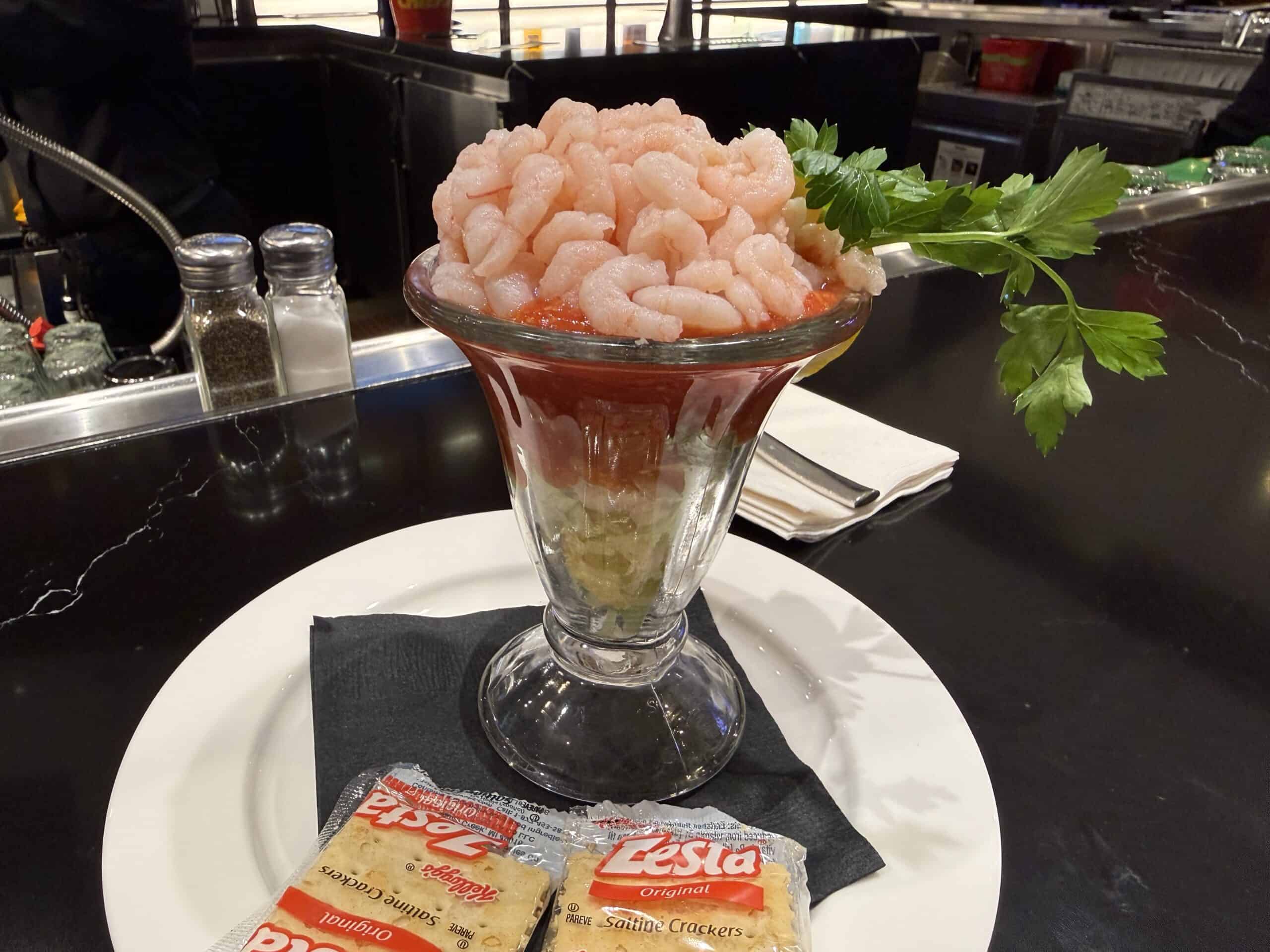 $2.99 Shrimp Cocktail side profile with a pile of shrimp on top, on a bed of cocktail sauce and lettuce.