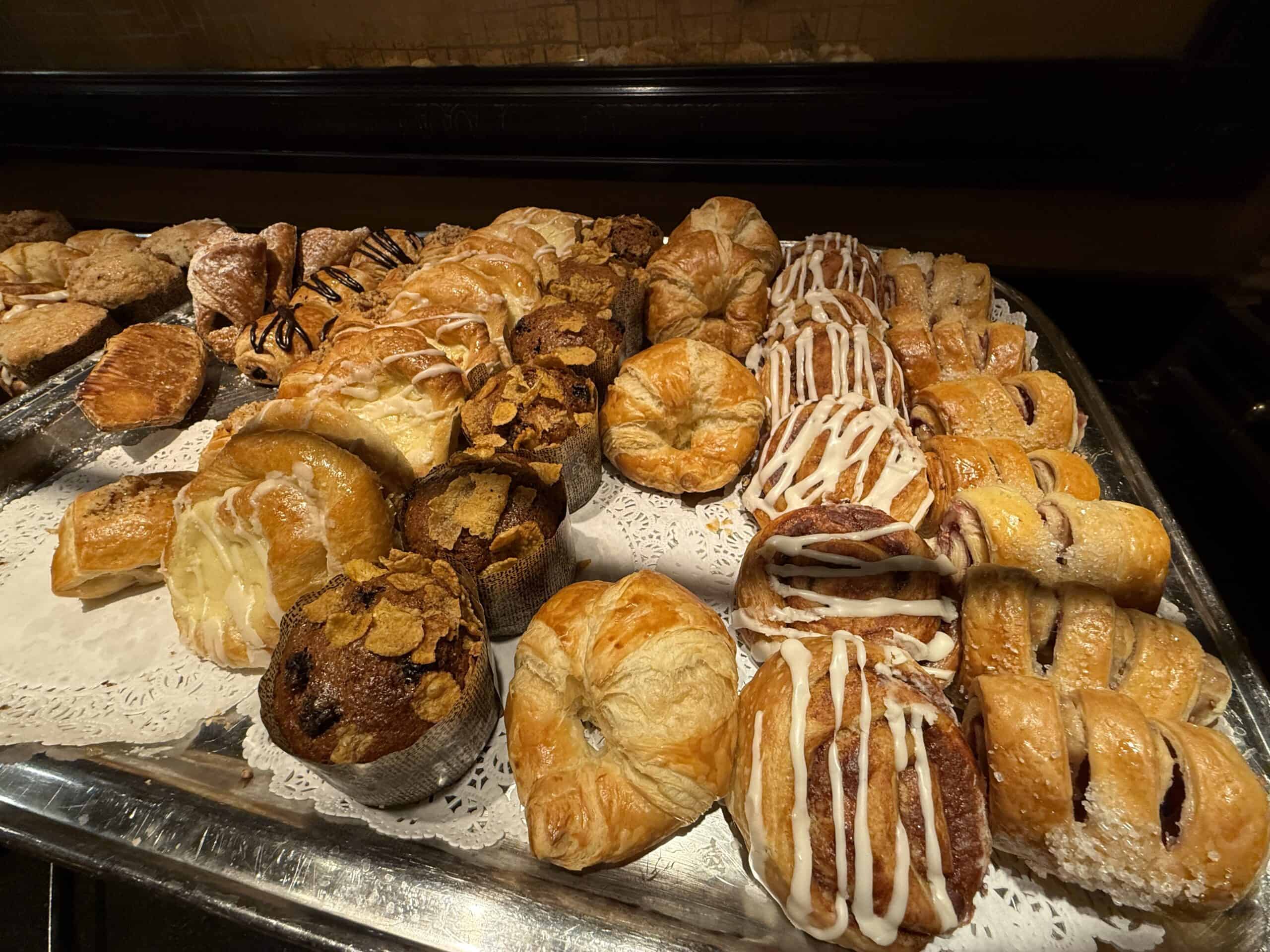 Pastries, muffins, and donuts on a tray.