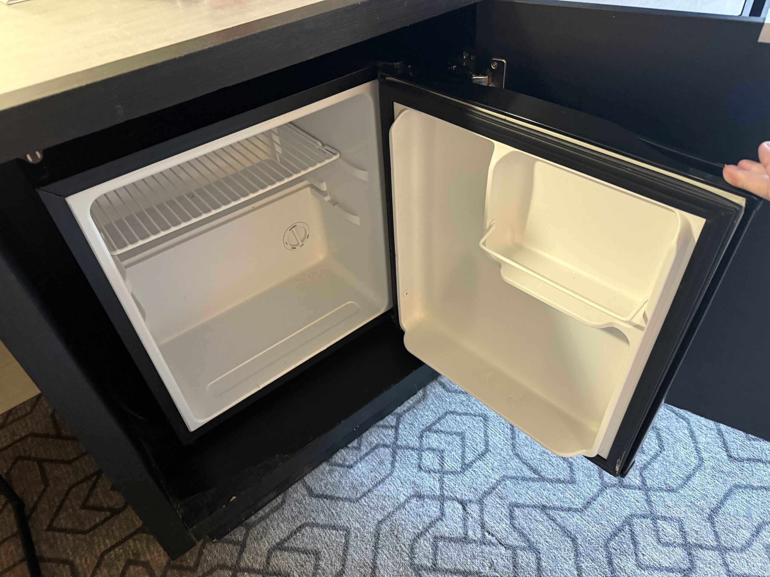 An open empty mini fridge.