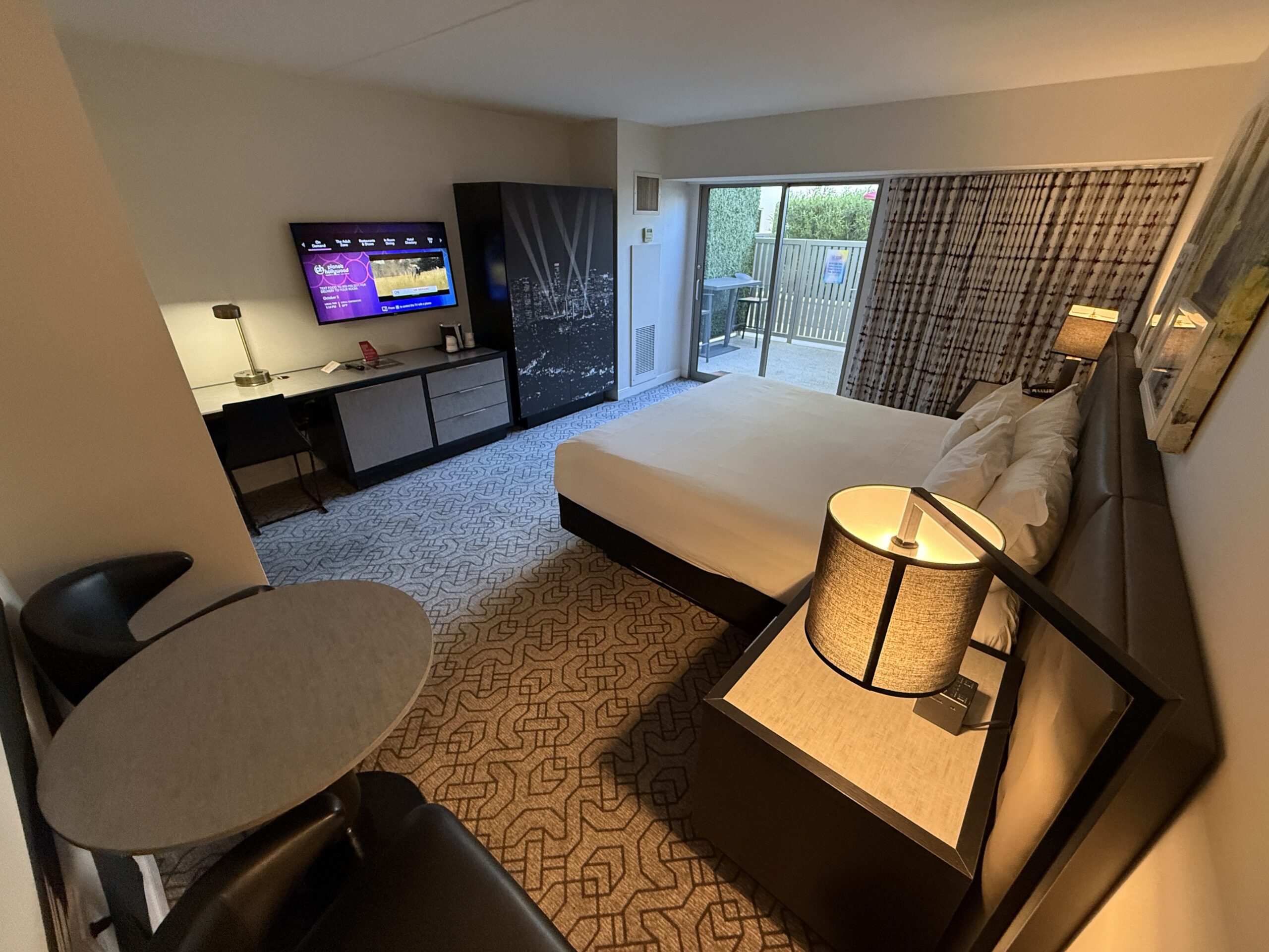 Another wide angle of the room, which shows the bed pointed at the tv, and a sliding door out to the patio in the background.