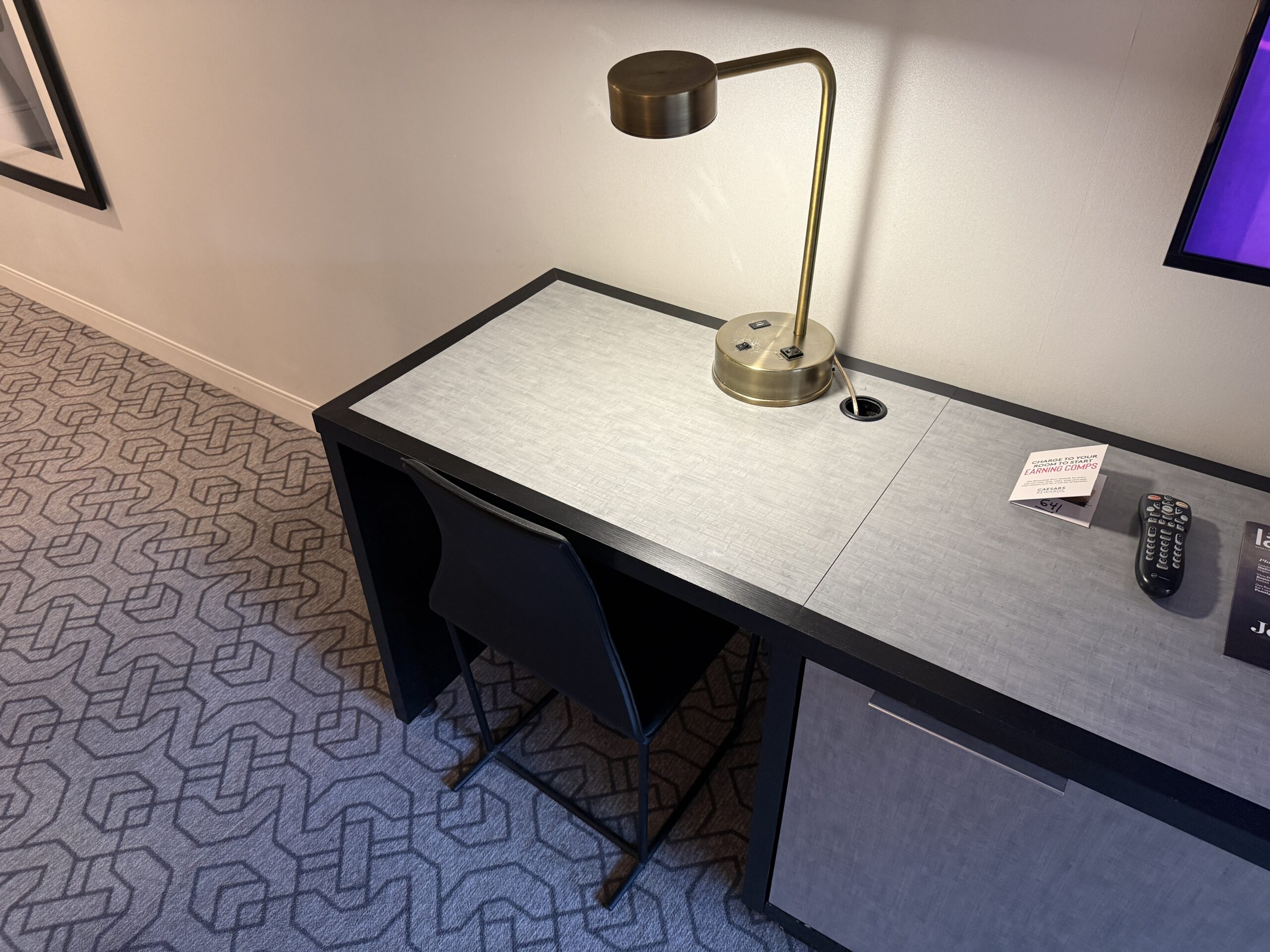 A small workdesk with a light on the countertop.