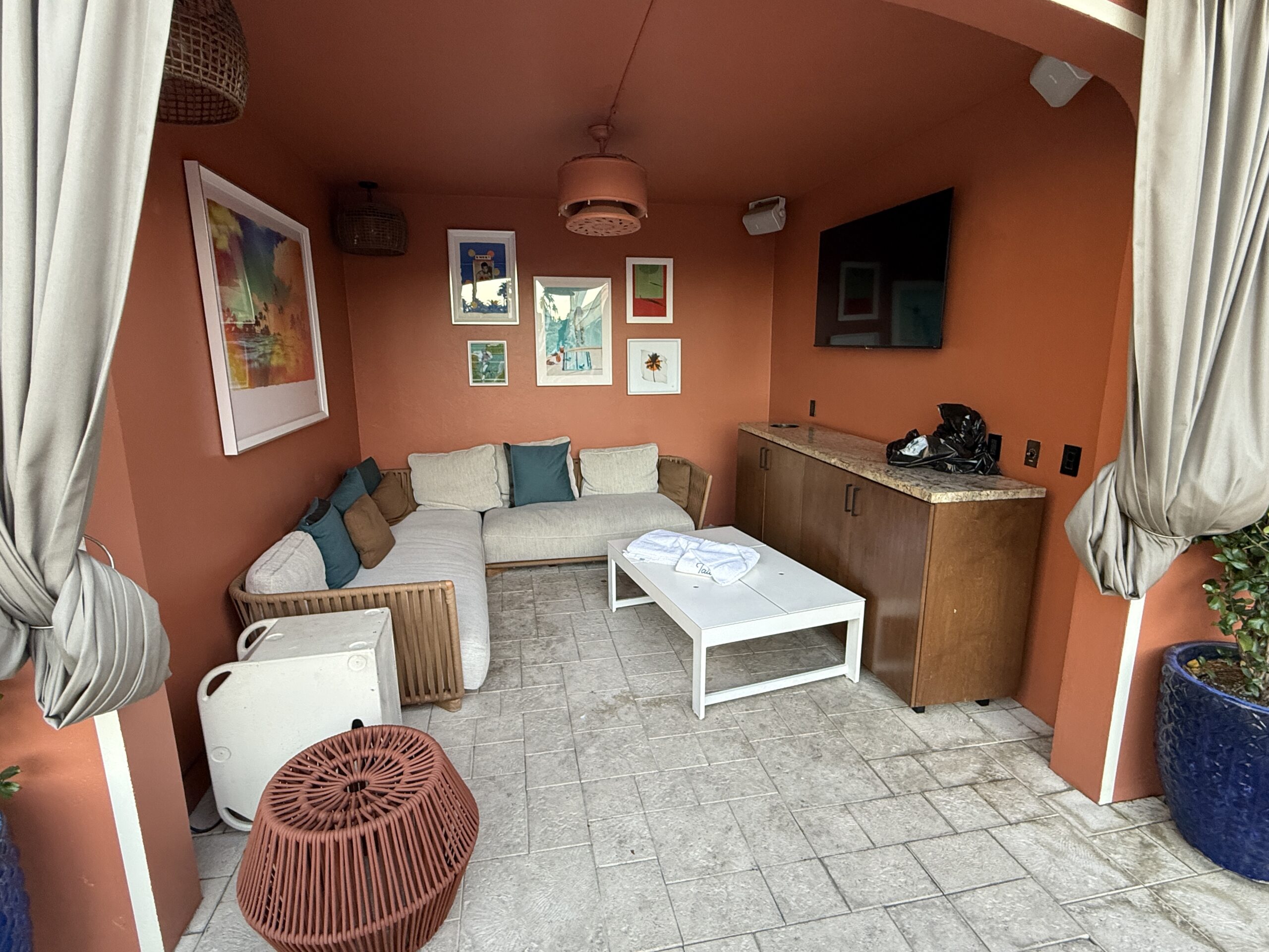 Inside a Cabana at Tailgate Beach Club, which has it'so own couch, TV, fan, and loungers out front.